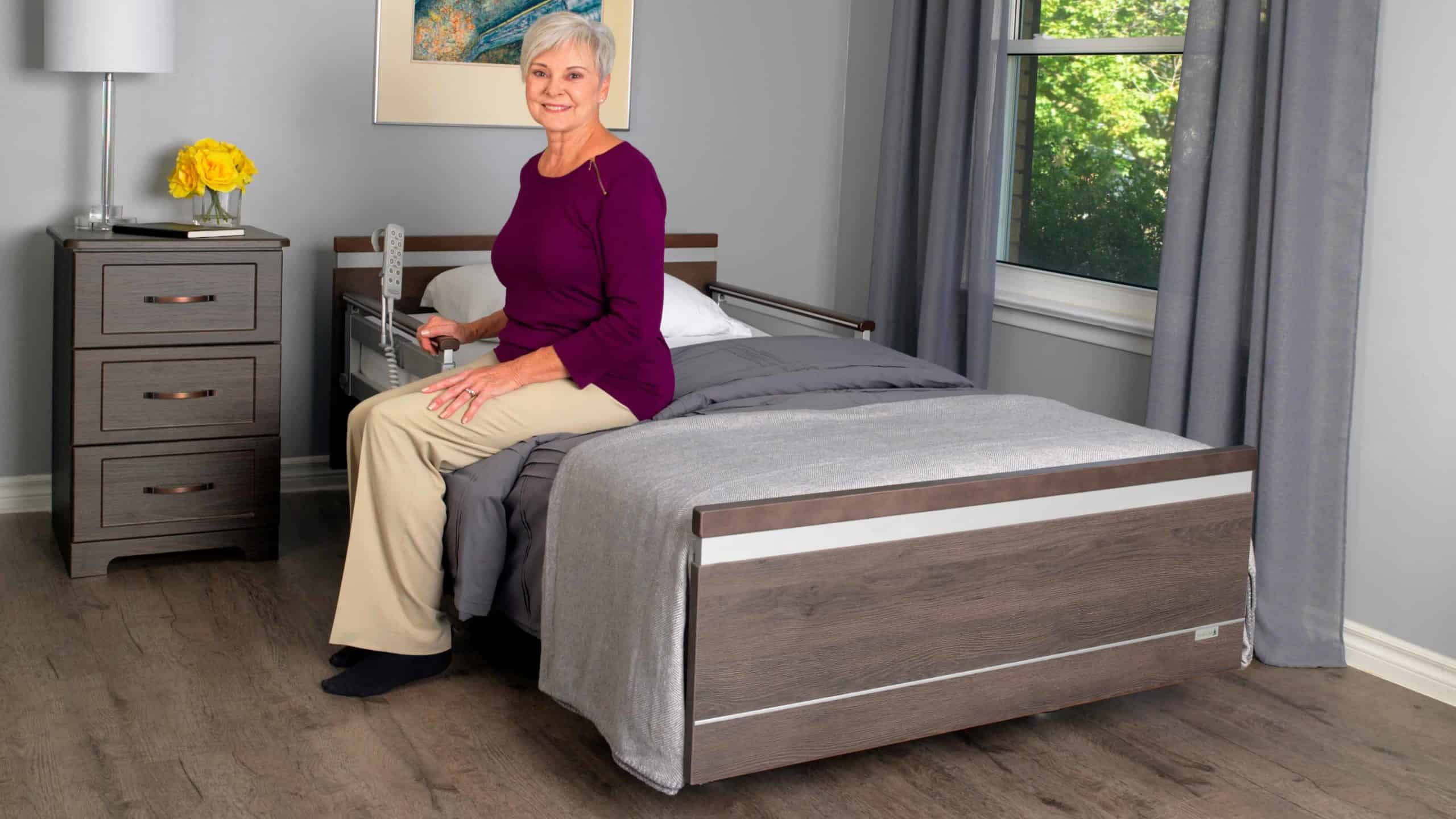 a woman sitting on a bed in a bedroom.