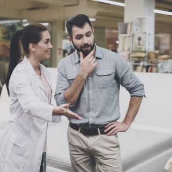 A man and woman discussing furniture options in a store.