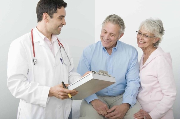 a man and a woman are looking at a clipboard.