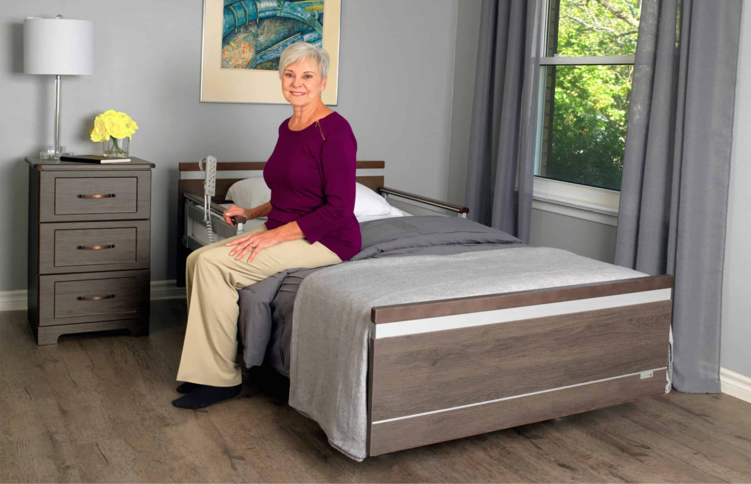 a woman sitting on a bed in a room.