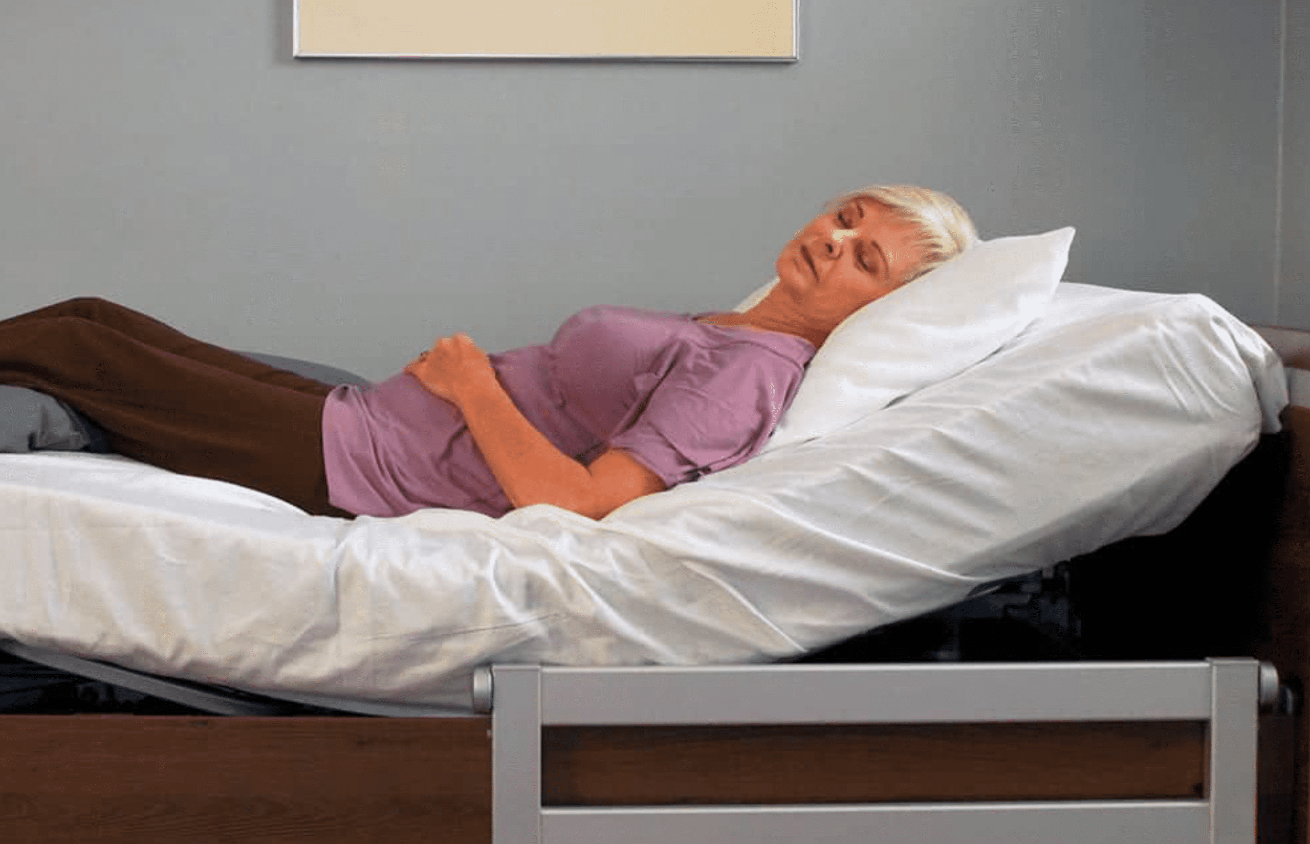 a woman laying on a bed with a pillow on top of it.