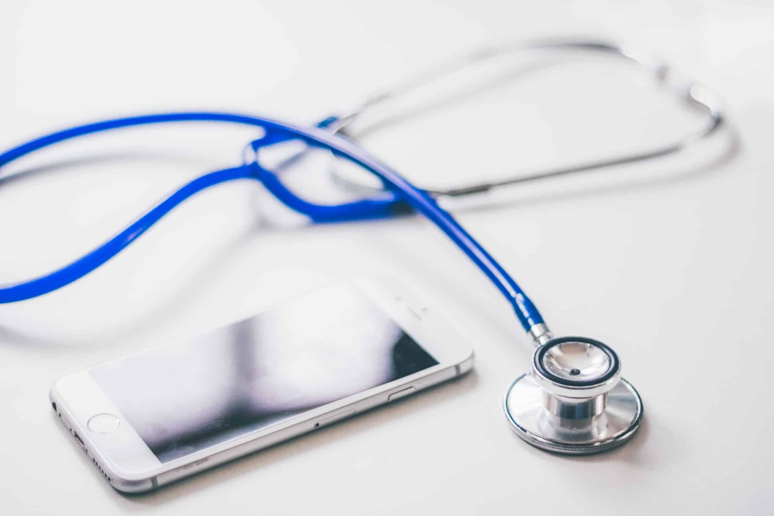 a phone and a stethoscope on a table.