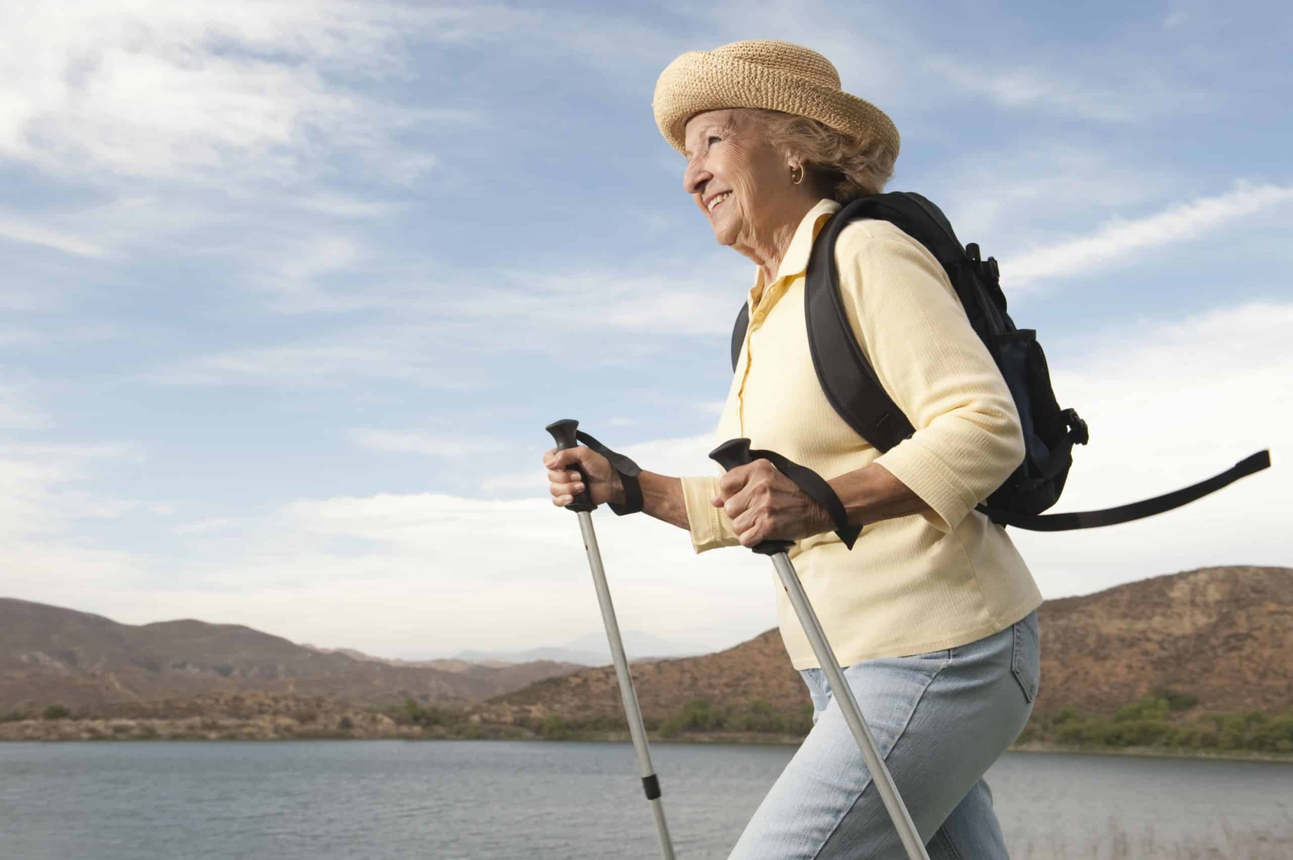 a woman with a backpack and walking sticks.