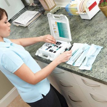 a woman standing in front of a counter with a laptop.