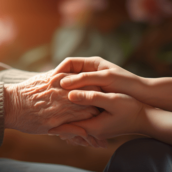 A woman holding an elderly person's hand.