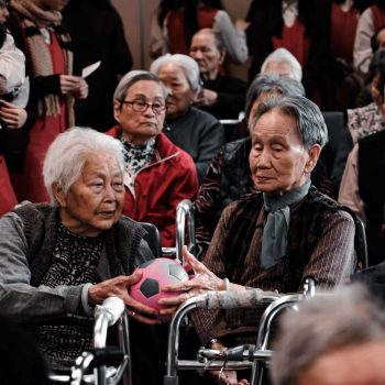 a group of elderly people sitting next to each other.