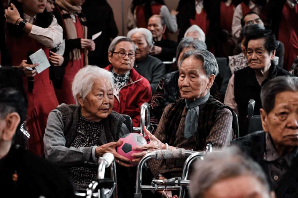 a group of elderly people sitting next to each other.