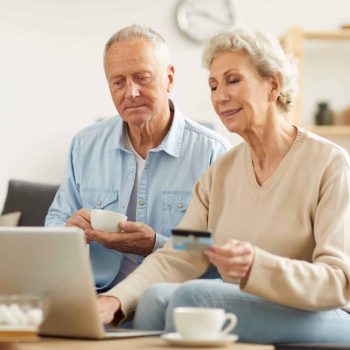 An older couple using a laptop at home shopping for hospital beds for home