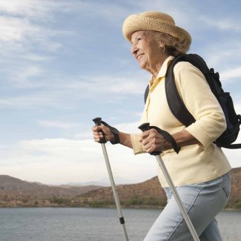 a woman with a backpack and walking sticks.