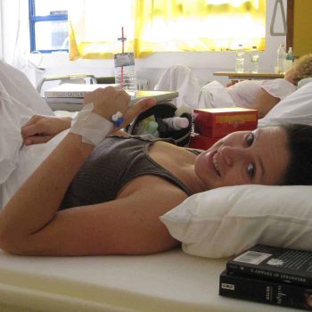 a woman laying in a hospital bed with an iv in her hand. a woman laying in a hospital bed with an iv in her hand.