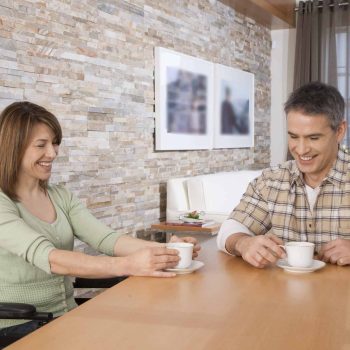a man and a woman sitting at a table with cups of coffee. a man and a woman sitting at a table with cups of coffee.