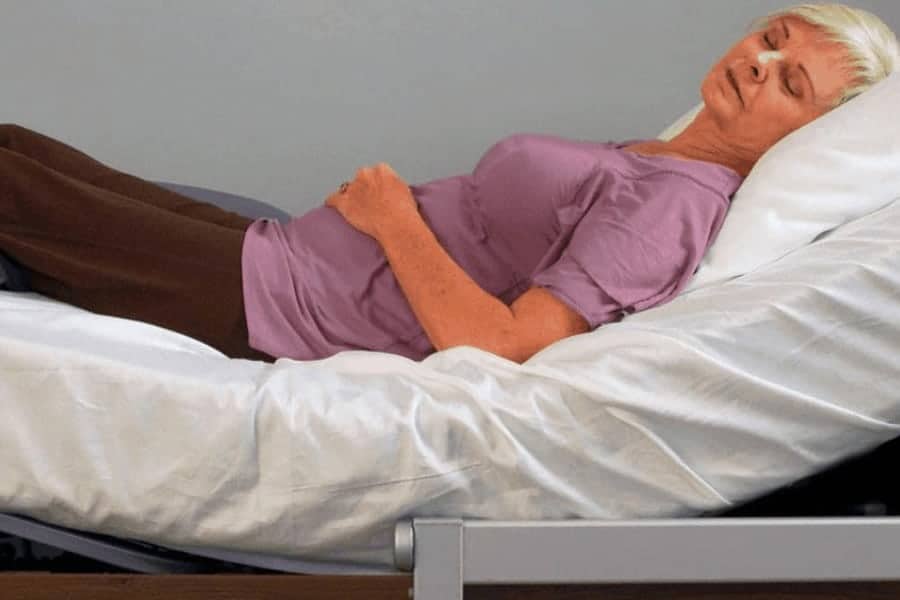 a woman laying on a bed with a pillow on top of it.